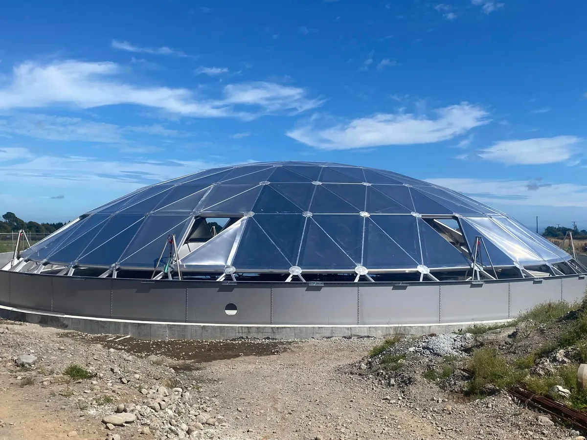 Clear panelled geodesic dome roof on a completed tank, seen from ground level