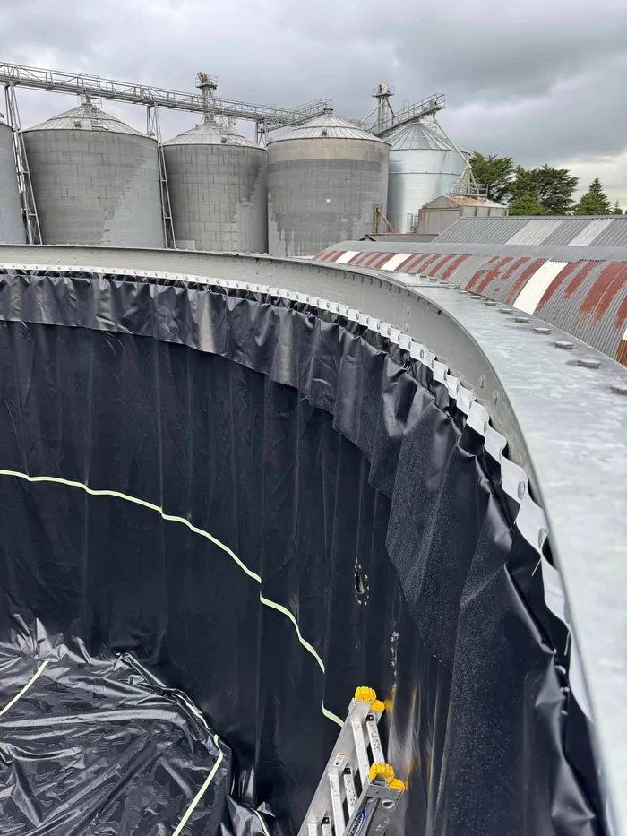 The new liner hung down the inside of the tank wall and clamped along the top rail